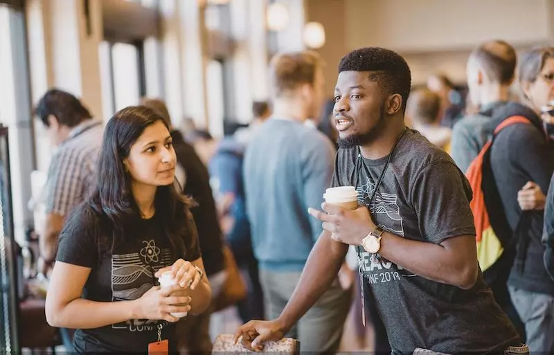 A hallway conversation between two people at React Conf